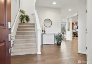 Tall ceilings and engineered hardwoods great you into the home.