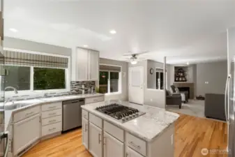 The stunning, updated kitchen overlooks the backyard and features sleek stainless steel appliances, including a double oven and gas cooktop. Designed with an open layout, it seamlessly connects to the family room—perfect for entertaining and staying connected with guests.