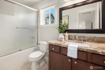 Guest bathroom with upgraded countertop and shower door.