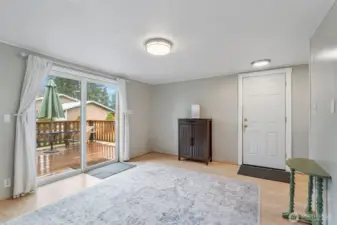 Looking through from the end of the kitchen, this is the family room with sliding doors to the deck, door (center) to the garage, and mudroom at the far right. Just to the right of the photographer is entry to the bath.