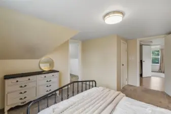 This is the primary bedroom again, looking back to the loft and 2nd upper bedroom. However, Note the open doorway leading to an extra finished room!