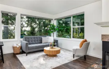 Expansive picture windows frame lush tree tops for added privacy.