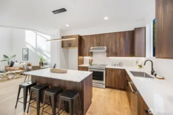 Seated island also offers more storage, stainless appliances, quartz counter tops. Photo is of model home of same floorplan. Color schemes of finishes may vary.