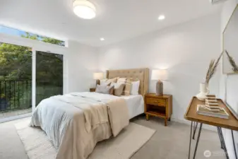 Primary suite offers two closest (one walk-in), en-suite bathroom.  Over size slider steps out to balcony.  Photo is of model home of same floorplan. Color schemes of finishes may vary.