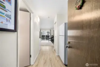 Welcoming entry hallway featuring durable LPV flooring throughout, leading into a bright and cozy living space. The thoughtful layout offers an easy flow from entry to the main living area, ideal for mountain living with space for gear and everyday comfort. Natural light draws you toward the balcony beyond—perfect for relaxing after a day on the slopes at Alpental.