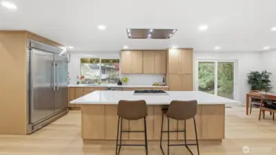 At the heart of the home, the chef-inspired kitchen showcases sleek quartz countertops, premium cabinetry, designer fixtures, and a high-end Forno refrigerator that anchors the space with both function and flair.