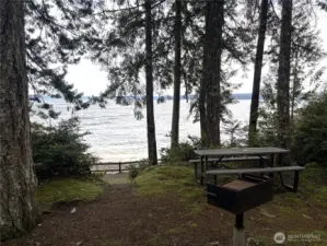 Community beach with picnic tables and cooking grills.