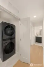 Dedicated laundry with a stacked washer and dryer and extra storage. Keep chores tucked neatly away.