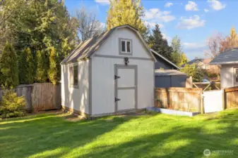 A storage shed provides practical space for tools and gardening needs.