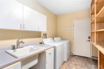 Large laundry room with built in shelving and cabinets.