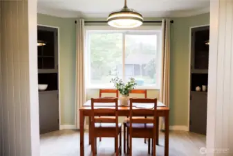 Charming dining room with built-in cupboards and a large window overlooking the front street.