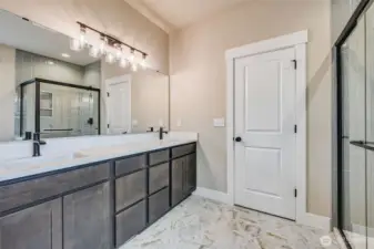 Primary Bath with private water closet. Slab counters and tile floors.