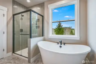 Primary Bath with tile shower and freestanding tub. Check out that view!