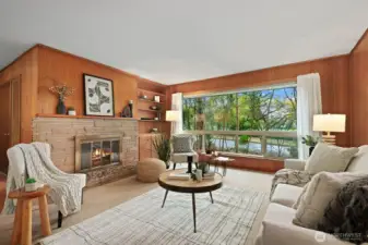 Gracious and open living room with a wood burning fireplace and large picture window.