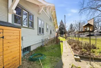 Side yard with storage shed, raised beds and bird feeder