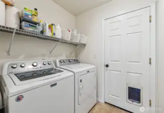 Laundry room leads to the huge garage that has room to have a car lift and space for hobbies. Washer and dryer stay!