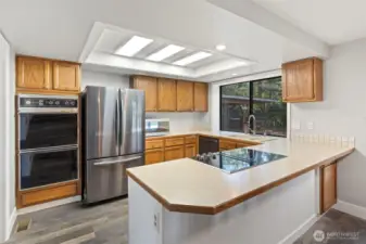 Charming traditional kitchen with timeless cabinetry, brand-new downdraft stove, spacious counters, and abundant storage—perfect for everyday living and entertaining.