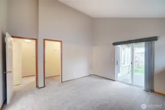 Primary bedroom has walk-in closet and view to the patio and backyard pergola covered with fragrant Wisteria.