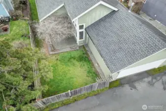 Close up of the patio and fenced yard area with Wisteria covered pergola.