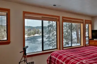Wake up to sweeping river views framed by large windows in the comfort of the primary suite.