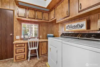 Nice sized laundry room with built in desk and large closet for storage