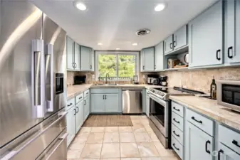 Stunning stainless steel appliances, tile floors, seafoam cabinets (newly refaced!), view of backyard. All appliances stay!