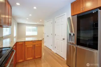 A refined view into the dining and living areas, featuring conveniently placed extra storage behind the doors on the right for added functionality.