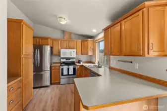 The kitchen features vaulted ceiling, lots of counter space, and stainless appliances.