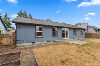 Fenced backyard with patio, raised garden beds and garden shed.
