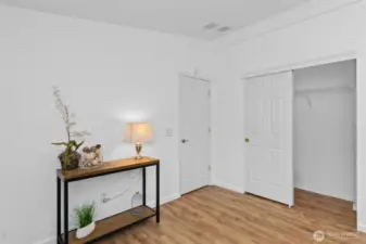 Primary bedroom looking at the door and closet