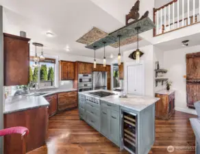 This incredible remodeled kitchen with all new Bosche appliances (2023) custom island with thoughtful design and placement of drawers cabinets for daily use, beverage cooler, and ceiling art are repurposed window shutters from India.
