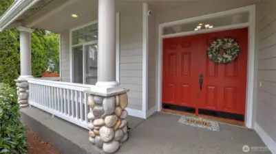 Double front doors open to a welcoming porch—perfect for sipping your morning coffee and enjoying the fresh air