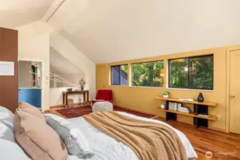 Two deep closets flank the wall of windows for ample storage