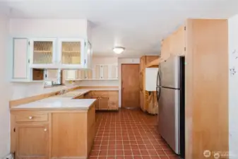 Another kitchen shot to door leading to second living room or rec space and laundry room