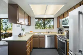 Vintage mid-century kitchen, beautifully intact, where treetop outlooks through broad windows brighten the space with a sense of calm and connection.
