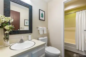 Main floor bath with Marmoleum flooring, a durable and stylish mid-century hallmark, paired with full tub and vanity.