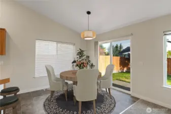 Sunlit dining space with backyard access through sliding glass doors—perfect for morning coffee or effortless indoor-outdoor entertaining.
