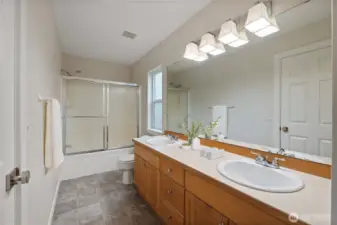 Bright and spacious ensuite with dual sinks, updated lighting, and a full shower/tub combo—designed for comfort and convenience.