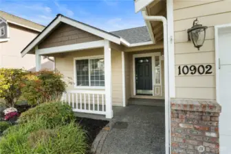 Inviting covered entry with, charming porch, and well-kept landscaping that welcomes you home.