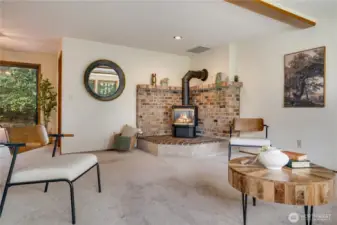 Wrapped in brick, warm wood accents, and views of lush greenery, this spacious room offers an inviting, cozy feel perfect for relaxed gatherings and everyday connection.