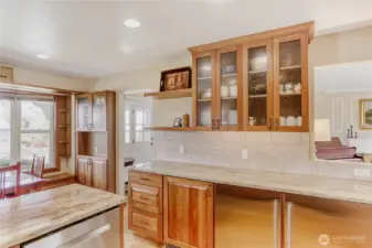 Sleek cherry glass cabinetry, granite countertops, and thoughtful built-ins for added function.