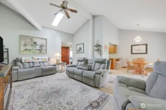 Another view of the living room with the front door in the background, and the dining area on the right.