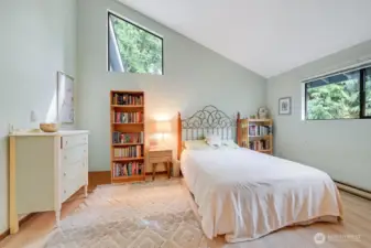 The roomy primary bedroom offers vaulted ceilings, natural light, newer floors, a walk-in closet & private bath.