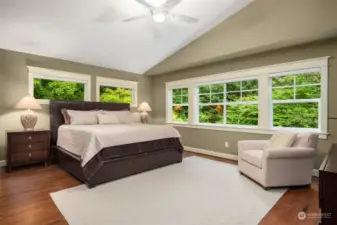 Primary bedroom with hardwood floors, vaulted ceiling and immense lush privacy.