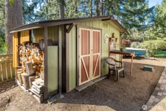 Charming garden shed with covered firewood storage