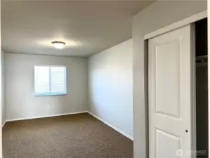 Guest bedroom with double sliding closet doors.