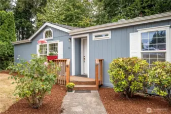 Beautifully landscaped front with lovely rose garden
