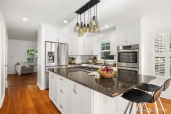 This updated kitchen is where everyone gathers—complete with granite counters, gas cooktop, double ovens, and oversized island.