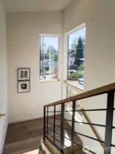 Stairwell with tall windows bringing the outside in