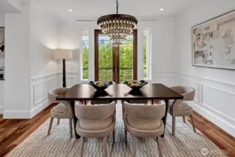 Striking detailing abound in this elegant dining room. Gorgeous lighting, wainscotting and French Door leading to a deck for BBQ's or just letting in the flowing breeze!